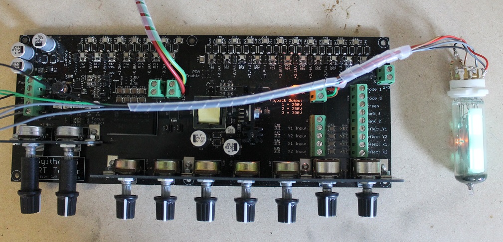 Figure 7 — An EM87 magic-eye valve glowing on the tester — the fluorescent ribbon target shows a bright bar whose shadow closes as the control voltage moves. Heater, target anode, and a control voltage are al…